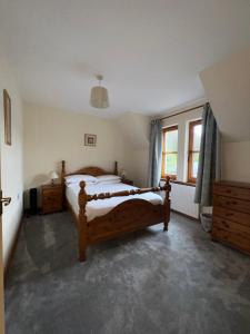 a bedroom with a wooden bed and a window at Nevis Croft Apartment 3 in Fort William
