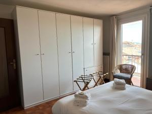 a bedroom with white cabinets and a bed and a chair at Appartamento Tosca in Verona