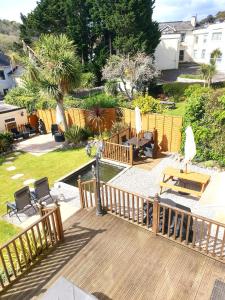 a deck with chairs and umbrellas in a yard at Appletorre House Holiday Flats in Torquay