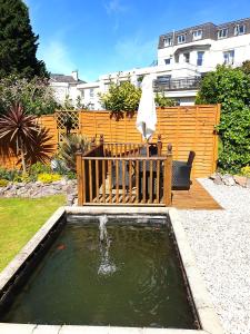 a pool of water with a koi in a yard at Appletorre House Holiday Flats in Torquay