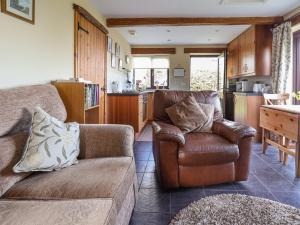 a living room with a couch and a kitchen at Dolphin Bach in Holywell