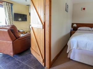 a bedroom with a bed and a chair and a television at Dolphin Bach in Holywell