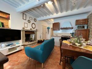 a living room with a table and blue chairs at Casa del Borgo in Cortona