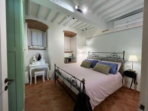 a bedroom with a large bed and a desk at Casa del Borgo in Cortona