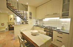uma cozinha com uma mesa e um fogão forno superior em Appartamento Maccari em Cortona