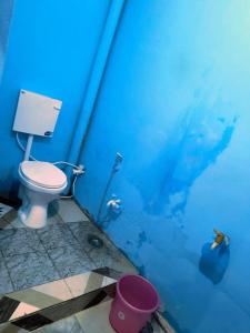 La salle de bains est pourvue d'un mur bleu et de toilettes. dans l'établissement Goroomgo Rainbow Residency Varanasi Near By Assi Ghat River - Excellent Service, à Varanasi