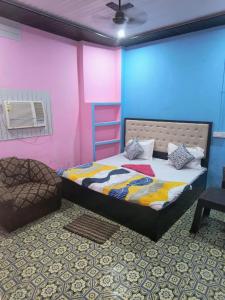 a bedroom with a bed and a pink and blue wall at Goroomgo Rainbow Residency Varanasi Near By Assi Ghat River - Excellent Service in Varanasi
