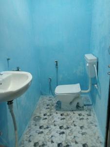 La salle de bains bleue est pourvue d'un lavabo et de toilettes. dans l'établissement Goroomgo Rainbow Residency Varanasi Near By Assi Ghat River - Excellent Service, à Varanasi