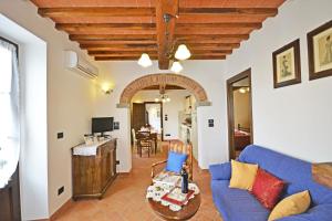 ein Wohnzimmer mit einem blauen Sofa und einem Tisch in der Unterkunft Villa Anita in Cortona