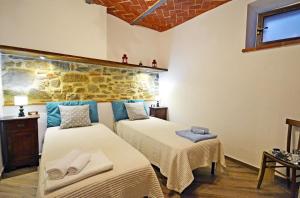 コルトーナにあるAppartamento Lunaの石壁のベッドルーム1室(ベッド2台付)