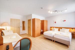 a bedroom with two beds and a table and a desk at Aktivhotel Alter Kaiser in Bad Ems
