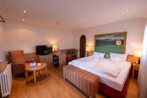 a bedroom with a large bed and a living room at Landidyll Hotel zum Kreuz in Glottertal