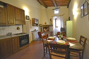 a kitchen with a table and chairs and a kitchen with a refrigerator at Casa Franci in Cortona