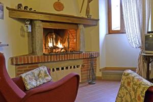 a fireplace in a living room with a fire at Casa Franci in Cortona
