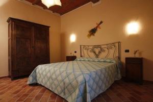 um quarto com uma cama e um armário de madeira em Villa Camelia em Cortona