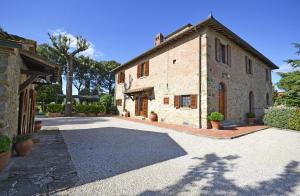 a large stone building with a courtyard in front of it at Casa I Pini in Cortona