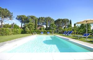 a swimming pool with chairs and an umbrella at Casa I Pini in Cortona