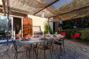 une table et des chaises sous une pergola sur une terrasse dans l'établissement Villa Mimosa, à Cortone