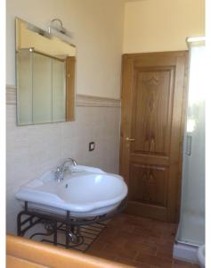baño con lavabo y puerta de madera en Villa Mira, en Cortona