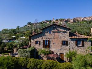 an old stone house with a hill in the background at Villa I Cocciai in Cortona