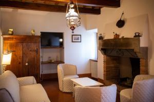 a living room with a fireplace and a tv at Villa I Cocciai in Cortona