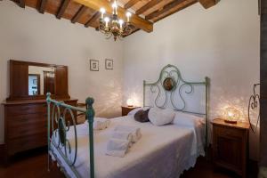 a bedroom with a bed with white sheets and a chandelier at Villa I Cocciai in Cortona