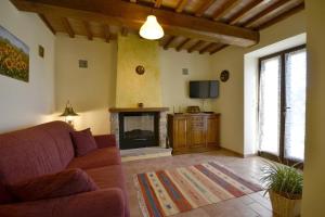 a living room with a couch and a fireplace at Villa Fiordaliso in Poggioni