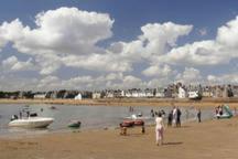 a group of people on the beach with boats in the water at Ingleside Cottage in Elie