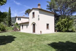 a large white house with a grass yard at VILLA SAN PIETRO in Cortona