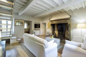 a living room with white furniture and a fireplace at Villa Magnolia in Cortona
