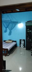 a bedroom with a bed and a blue wall at Quiet Nature Villa in Weligama