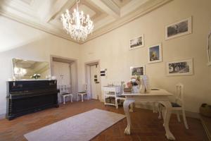 sala de estar con piano y mesa en Cortona Suite en Cortona