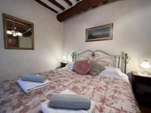 een slaapkamer met een bed met 2 kussens erop bij Casa Mirella in Cortona