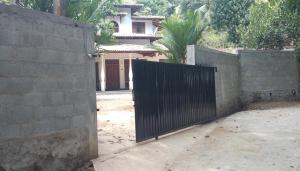 a fence with a gate in front of a house at Quiet Nature Villa in Weligama