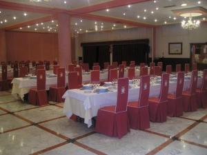 a large banquet hall with tables and red chairs at Hotel Begoña Park in Gijón