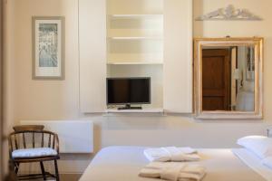 a bedroom with a bed and a tv and a chair at Casa Annateresa in Cortona