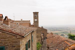 un vecchio edificio con una torre dell'orologio in lontananza di Appartamento Mancini a Cortona