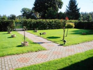 a brick path in a park with trees in the grass at Wohnung in Kopalino mit Garten und Grill in Kopalino