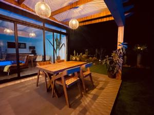 a dining room with a wooden table and chairs at Bungalow + Piscina independiente in La Oliva