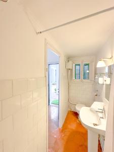 Baño blanco con lavabo y aseo en Wonderful House on the beach, en Caldes d'Estrac
