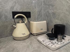 a tea kettle and a toaster on a counter at Padang Besar Syaripah Homestay in Padang Besar
