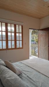 a bedroom with a large bed with a large window at La Maison d' Ivonne in Antón