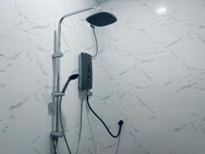 a shower with a phone hanging on a wall at Padang Besar Syaripah Homestay in Padang Besar +18 photos