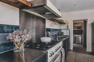 a kitchen with a stove and a vase of flowers at Heron House - Featured on 'Grand Designs' in Weston