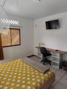 Schlafzimmer mit einem Bett, einem Schreibtisch und einem Computer in der Unterkunft MO TI KOTÉ in Cayenne