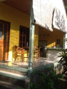 eine Veranda eines Hauses mit Stühlen und einem Tisch in der Unterkunft Bali Traditional homestay in Gianyar