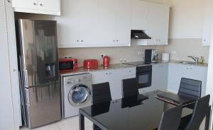 a kitchen with a refrigerator and a washing machine at Aphrodite Heights in Larnaca
