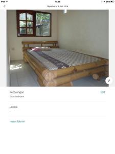 ein Schlafzimmer mit einem Holzbett in einem Zimmer in der Unterkunft Bali Traditional homestay in Gianyar