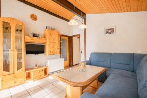 ein Wohnzimmer mit einem blauen Sofa und einem Tisch in der Unterkunft Ferienwohnpark Immenstaad am Bodensee Satteldachhaus Typ 10 SDS 048 in Immenstaad am Bodensee