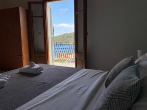 een slaapkamer met een bed en uitzicht op een raam bij Albatros rooms in Vathi